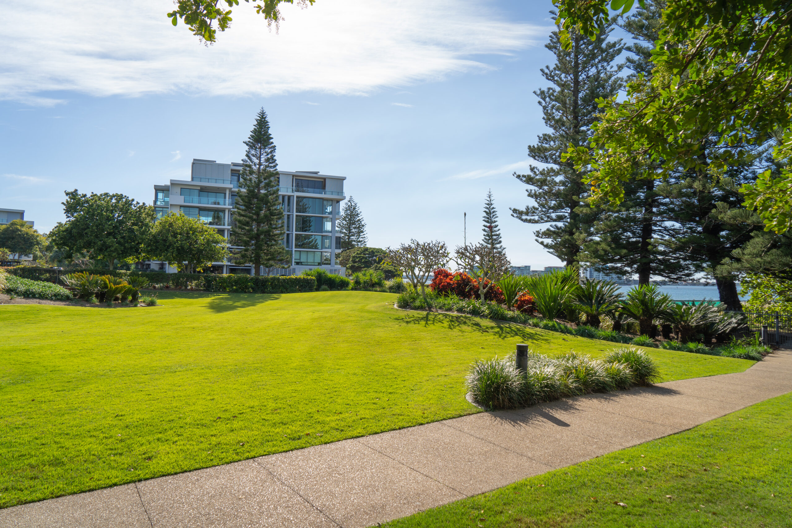 Landscaped lawn and garden beds maintained along the waterfront at Allisee Residential Apartments, Hollywell