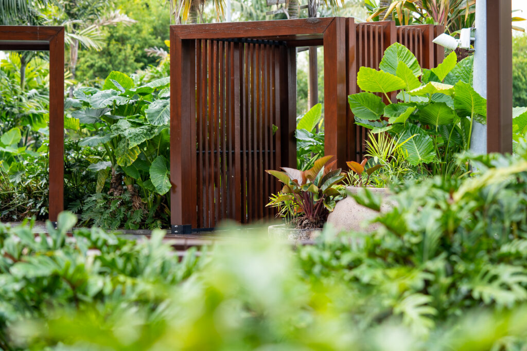 Timber gate framed by maintained tropical planting at Westfield Coomera