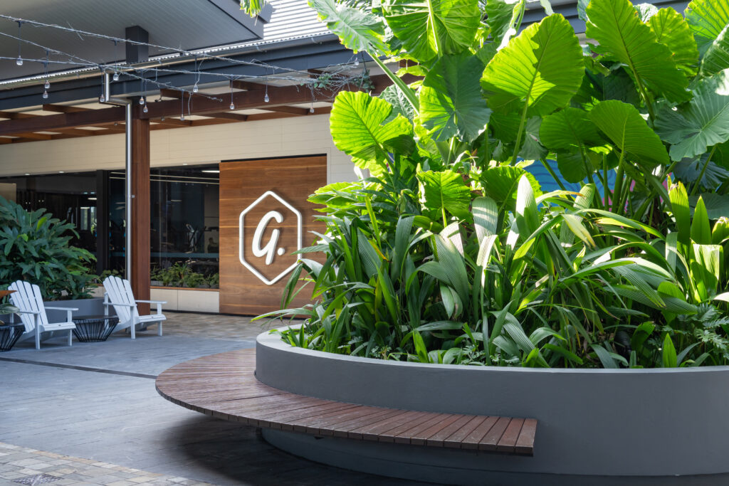 Maintained tropical planting bordering an outdoor lounge area at Westfield Coomera