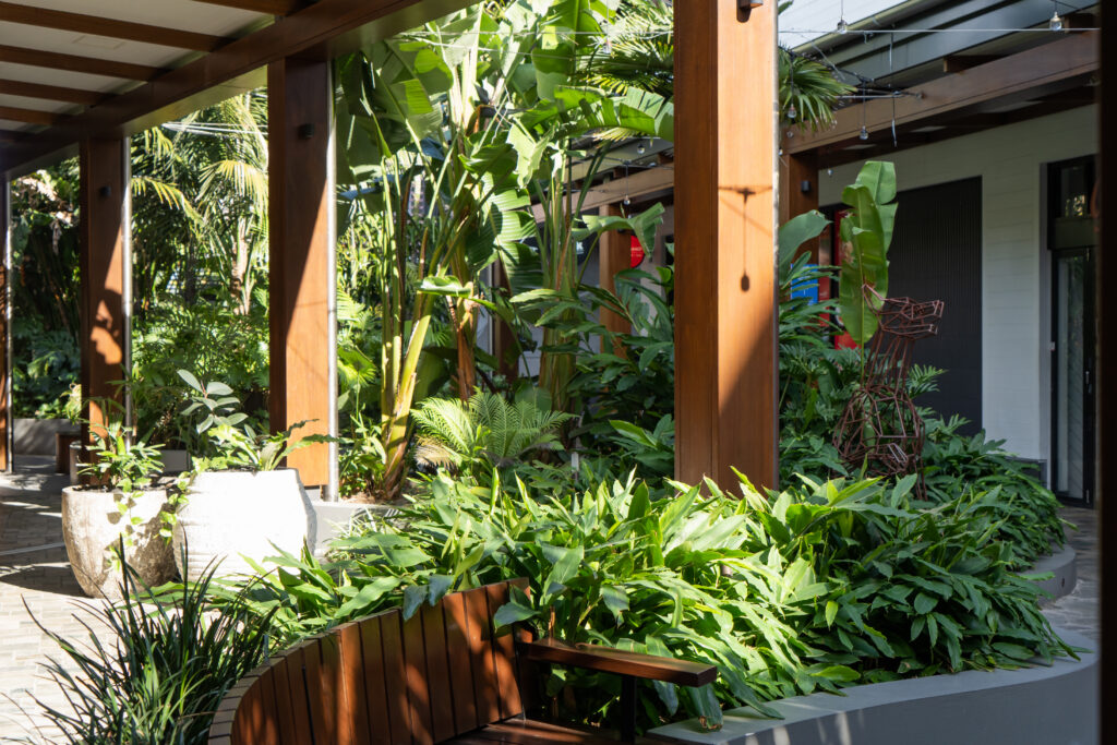 Tropical landscaping along a covered walkway at Westfield Coomera, maintained by Advance Landscapes