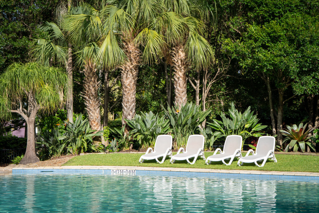 Maintained tropical garden with palms and bromeliads beside the pool at Grand Mariner