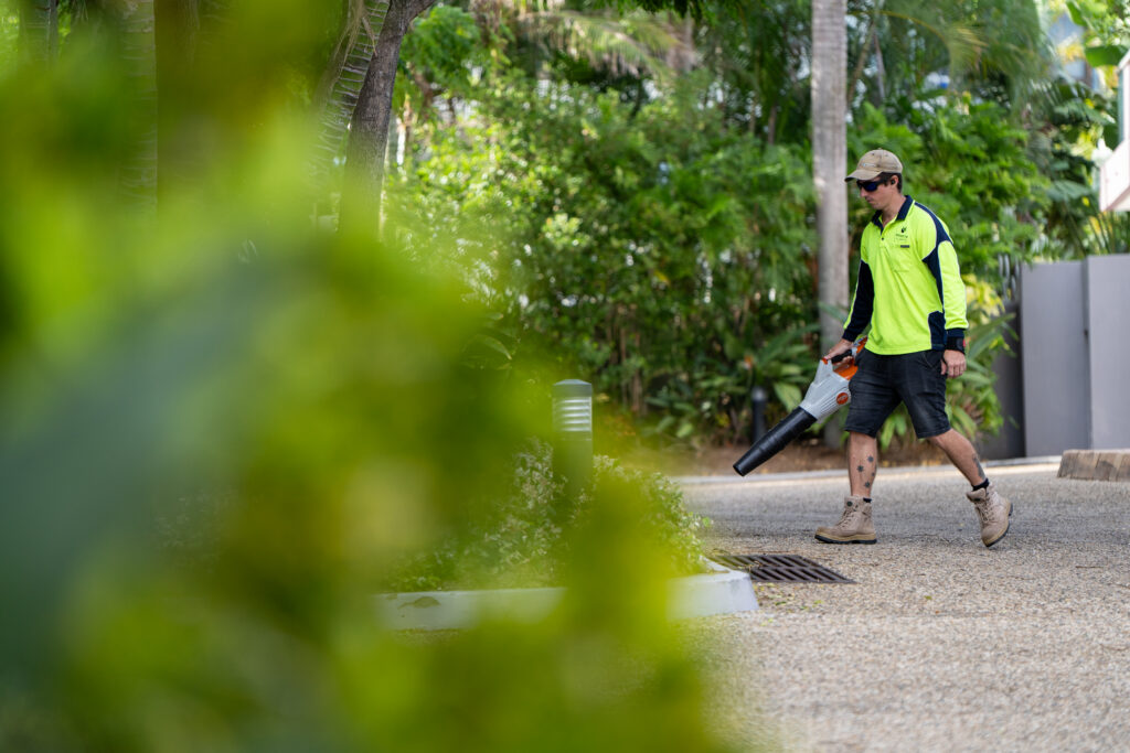 Advance Landscapes team member clearing a garden path at Grand Mariner